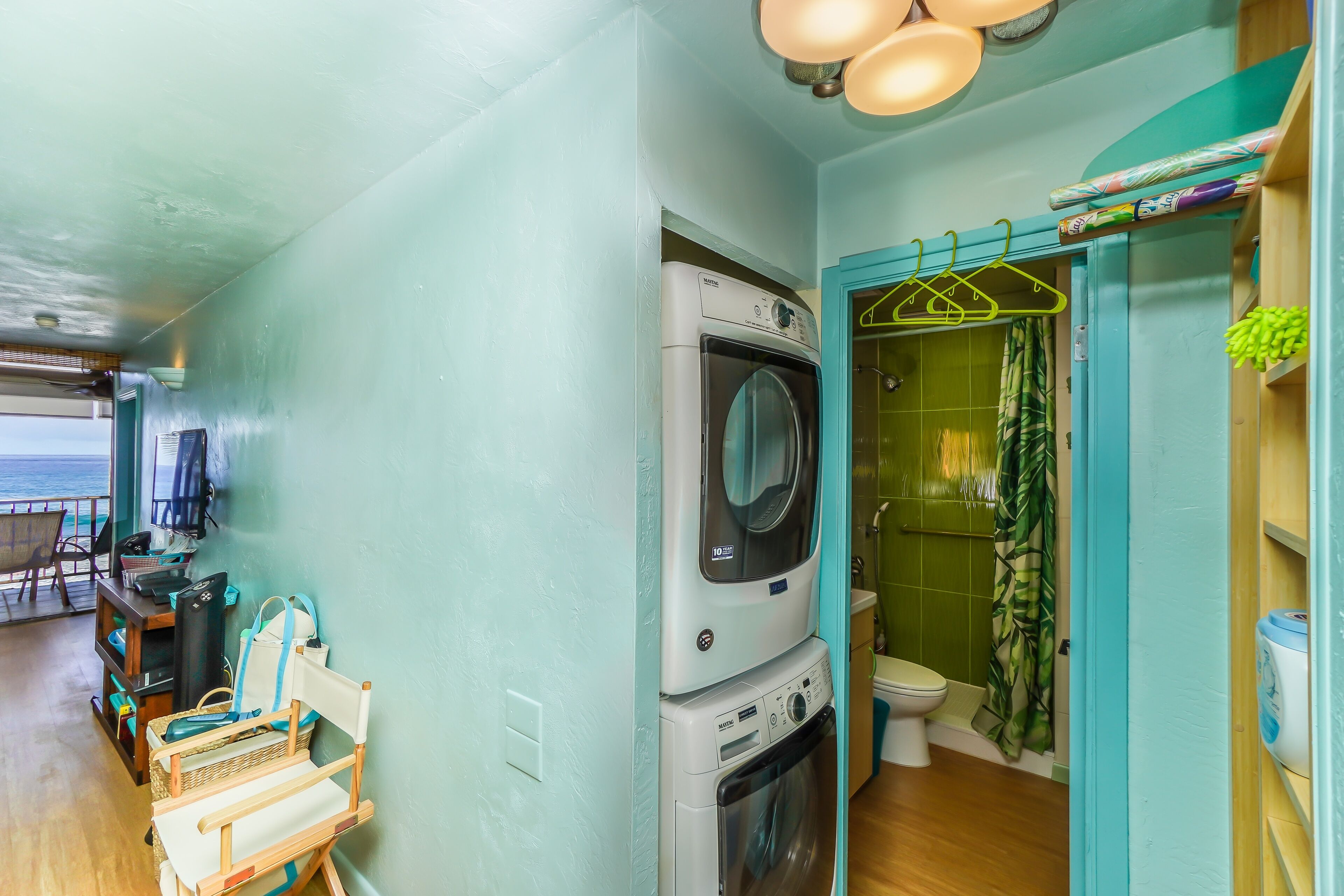 A compact laundry room with a washing machine, dryer, and a toilet.