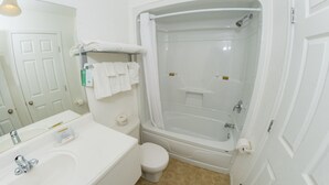 A bathroom with a white sink, toilet, and bathtub.