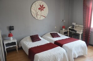 A room with two beds, a desk, and a chair. - Hôtel Le Week-End (Plouider)