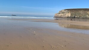 A beach with a rocky cliff in the background and a clear sky. - Logis Hôtel de France - Face à la Mer (Camaret-sur-Mer)
