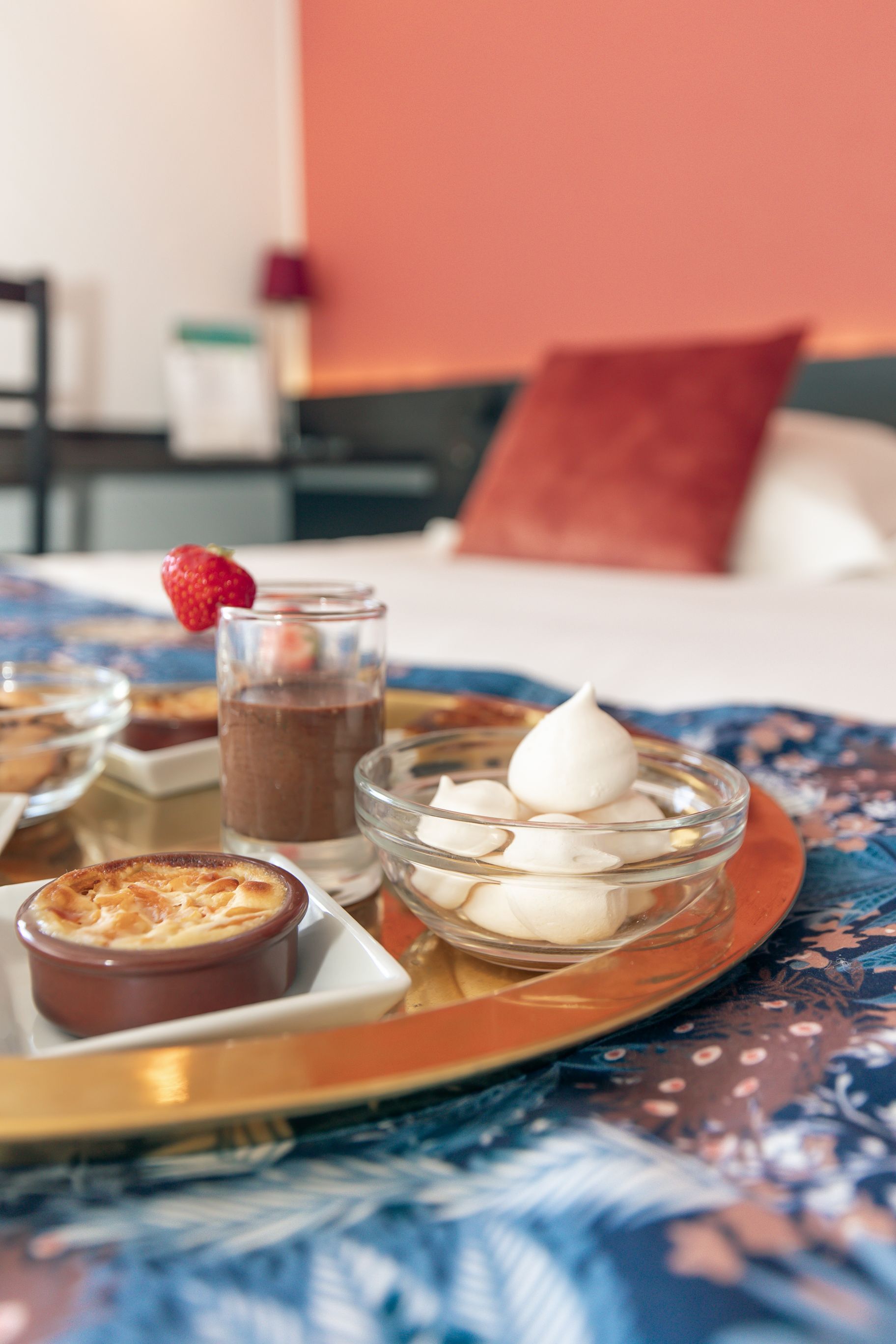A plat de postres amb mus de xocolata, crema batuda i una maduixa sobre una teatral.