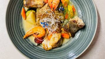 A plate of food with shrimp, fish, and vegetables.
