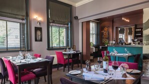 A restaurant with tables set for dining, a bar area, and a view of the outdoors. - The Lincoln Hotel (Lincoln)