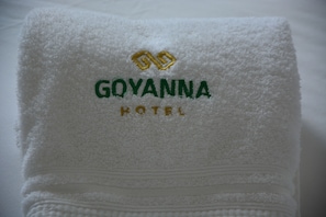 A folded white towel with embroidered text reading "GOYANNA HOTEL".