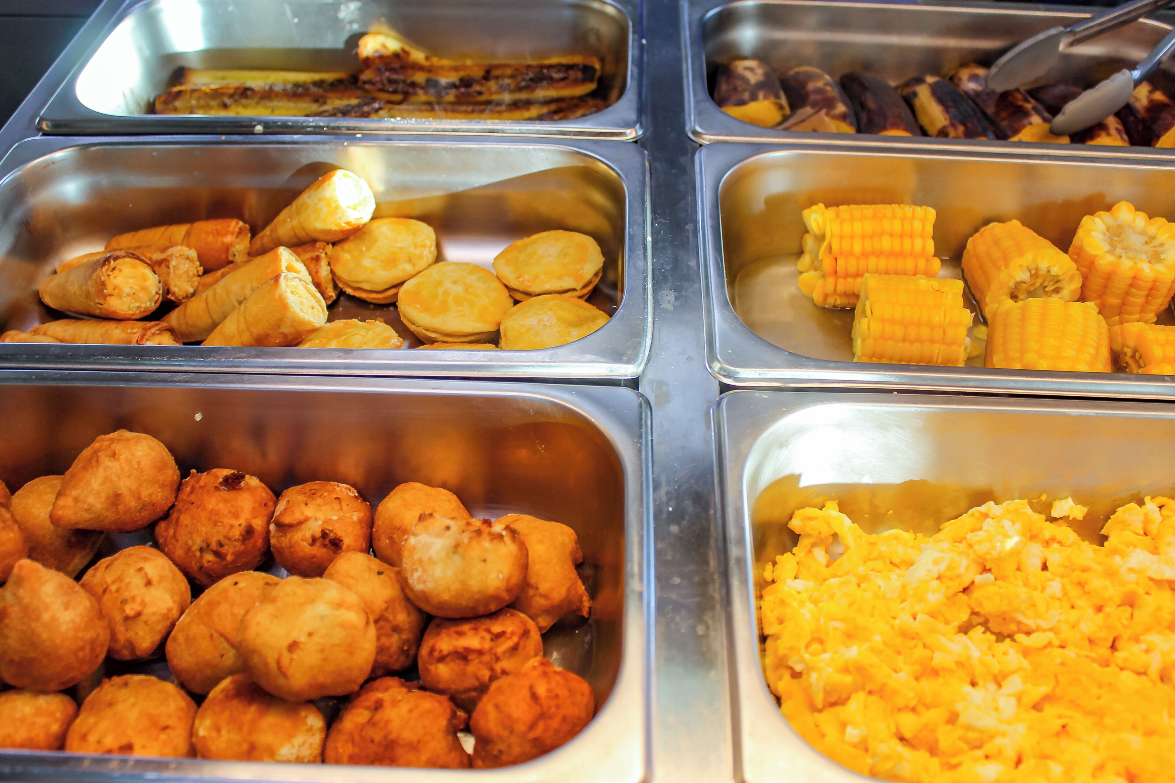 A buffet with various food items in separate compartments.