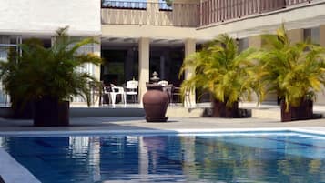 Una piscina al aire libre, sillones reclinables de piscina