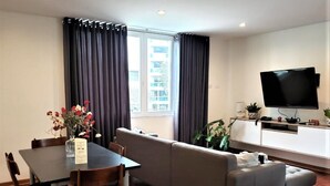 A modern living room with a dining table, sofa, and TV. - Private Modern Apartment in Pardo - Miraflores (Lima)