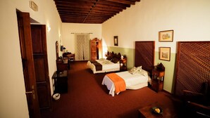 A traditional room with two beds, a wooden ceiling, and a desk with a chair. - Hotel Rural Villa de Agüimes (Aguimes)