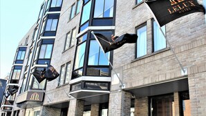A hotel building with multiple balconies and flags. - Lelux Hotel (Montreal)