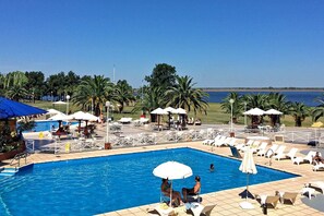 Piscine couverte, piscine extérieure, parasols de plage, chaises longues