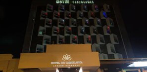 A hotel building with multiple illuminated windows and a sign that reads "HOTEL DE CAMARILLA."