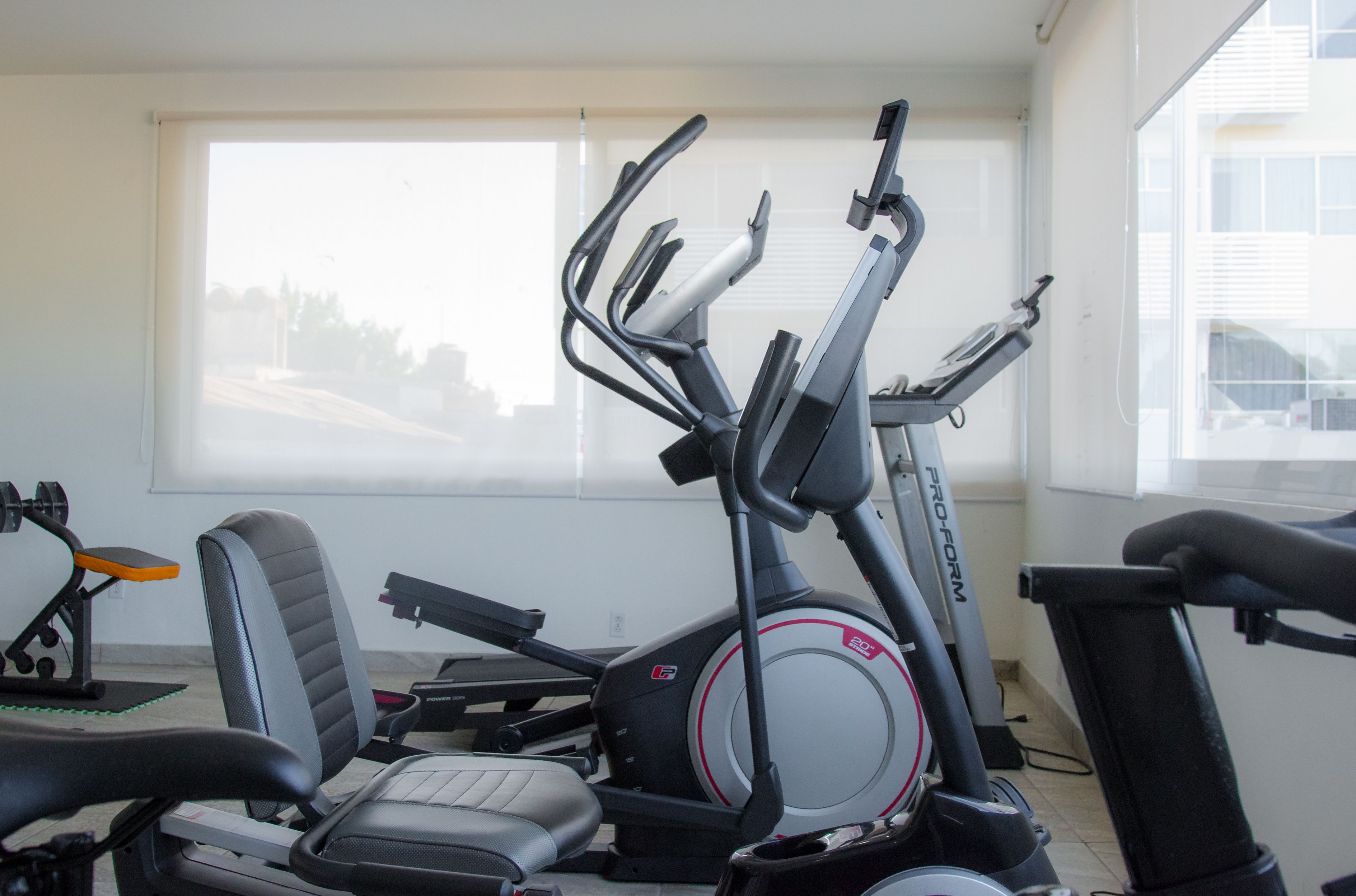 Et fitnessrum med træningsudstyr, herunder en motionscykel og et løbebånd.