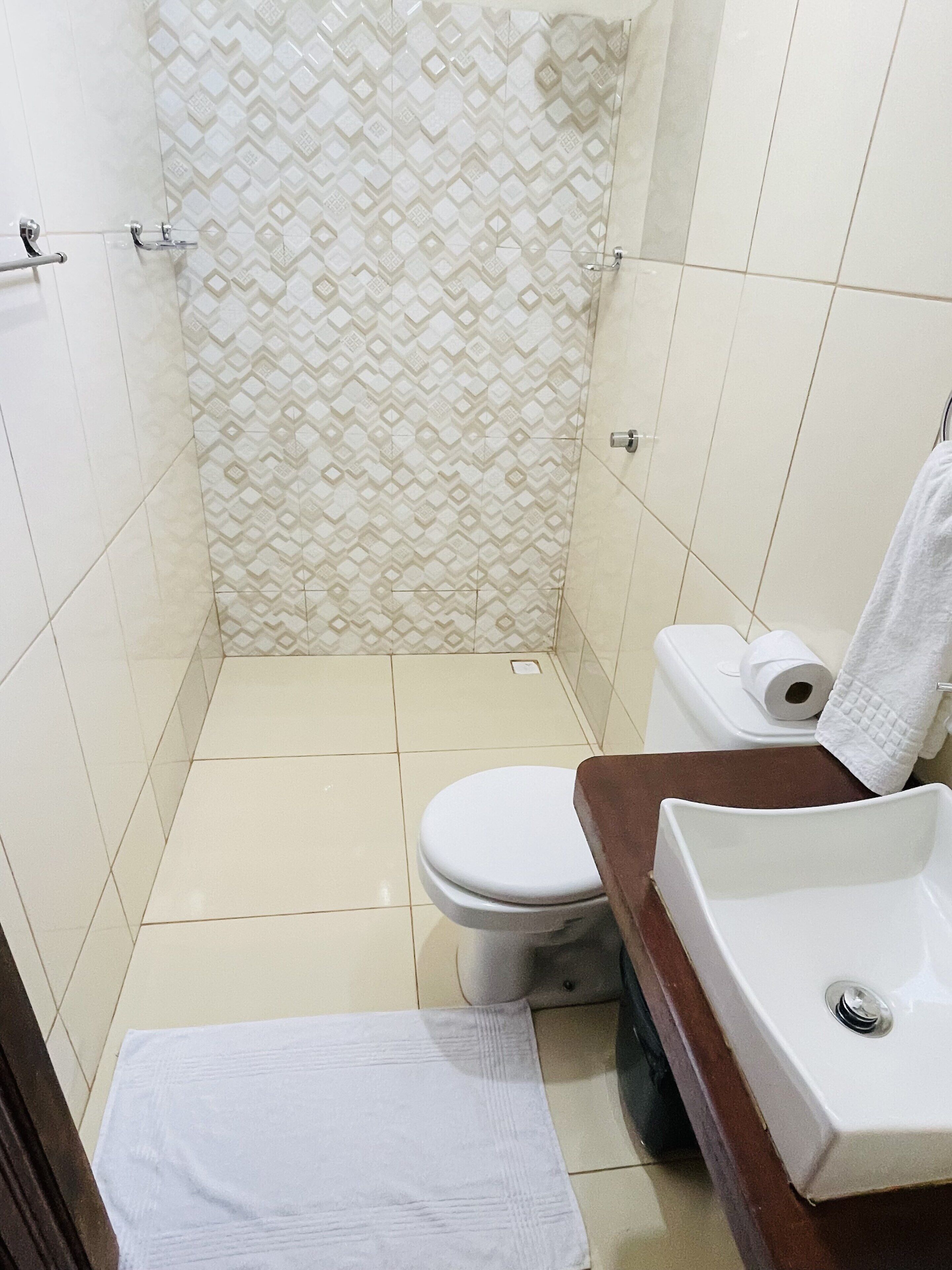 Un bany amb vàter, un lavabo i una zona de dutxa.