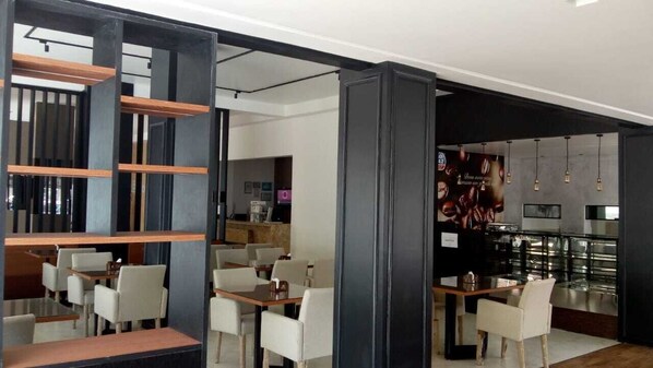 Un restaurante moderno con zona de bar, estanterías de madera y una disposición de mesas.