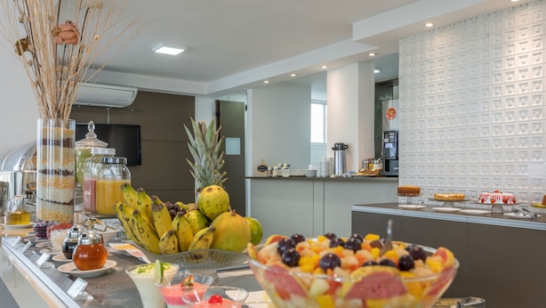Un buffet proposant une variété de plats, notamment des fruits, des desserts et des boissons.