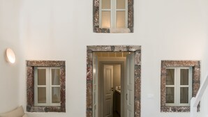 Un interior moderno con un sofá, dos mesas de madera y una escalera.