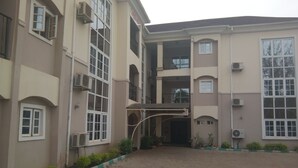 Un edificio de varios pisos con recepción, unidades de aire acondicionado y un patio empedrado.