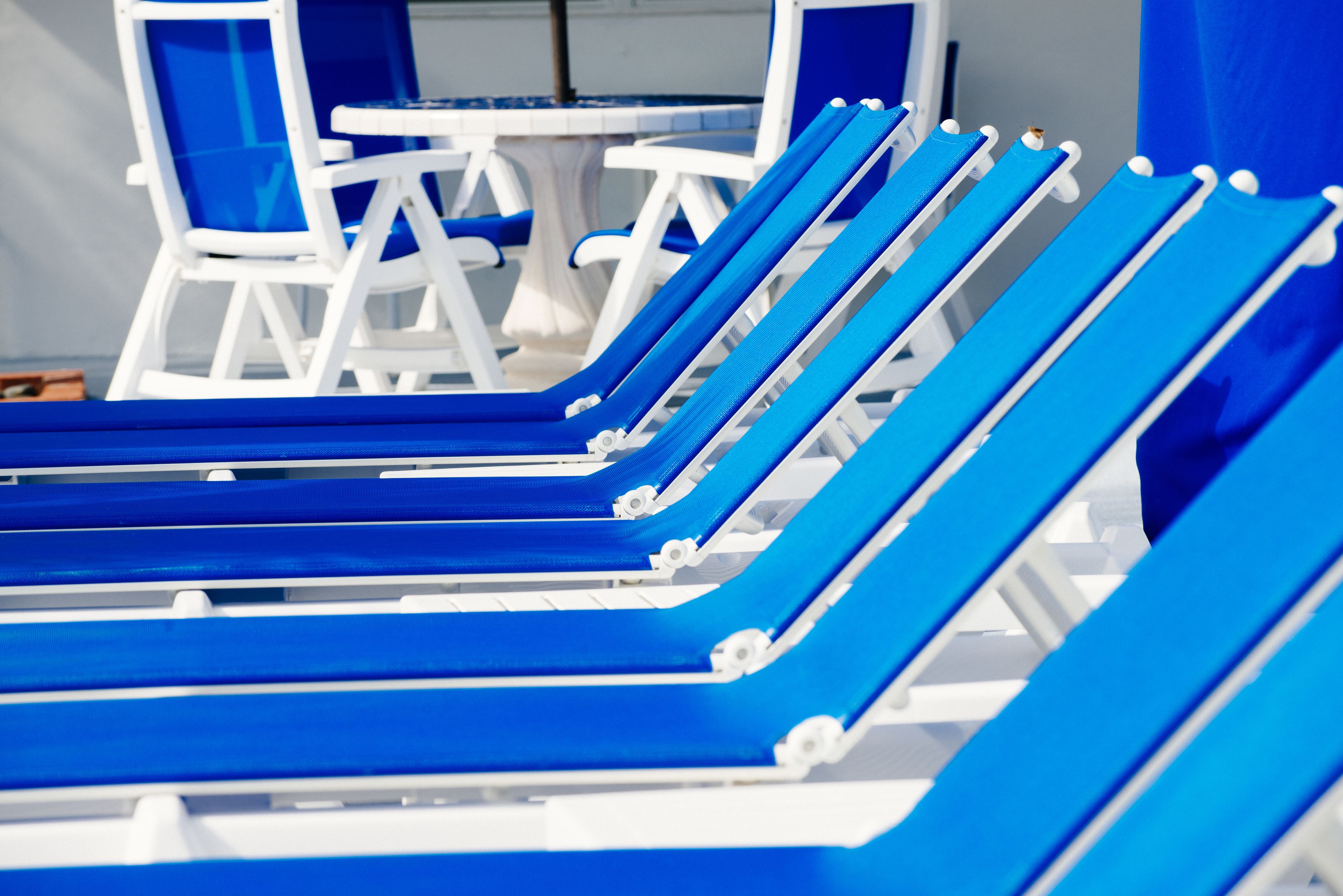 A row of blue lounge chairs with white frames, arranged in a row.