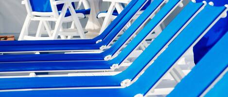 A row of blue lounge chairs with white frames, arranged in a row.