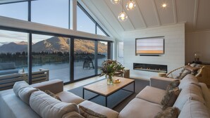 Un salon moderne avec un grand canapé, une table basse et une cheminée.