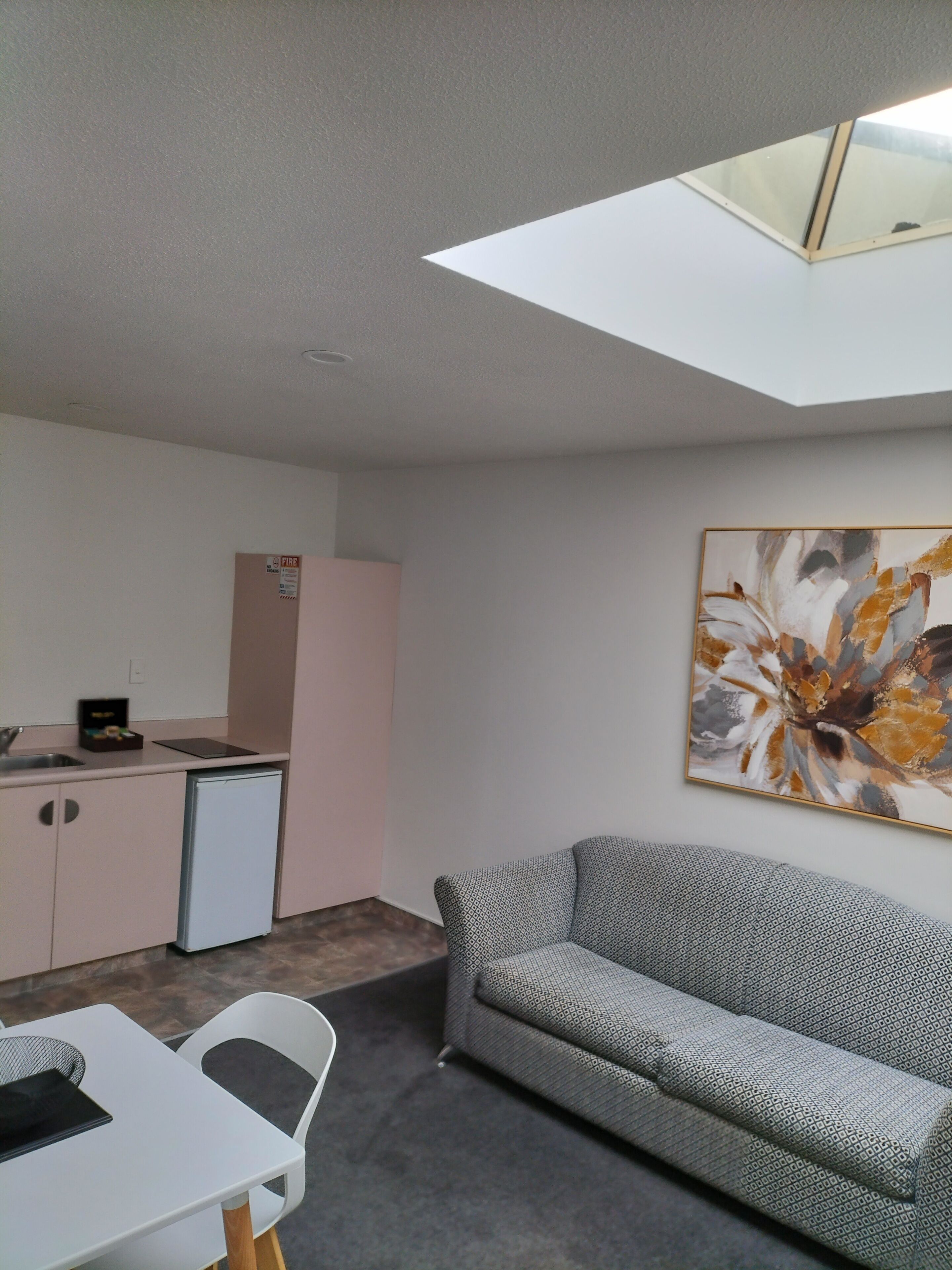 A compact living space with a kitchenette, a dining area, and a sofa.