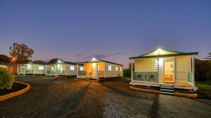 A row of mobile homes with attached porches, each with a small deck and a single window.