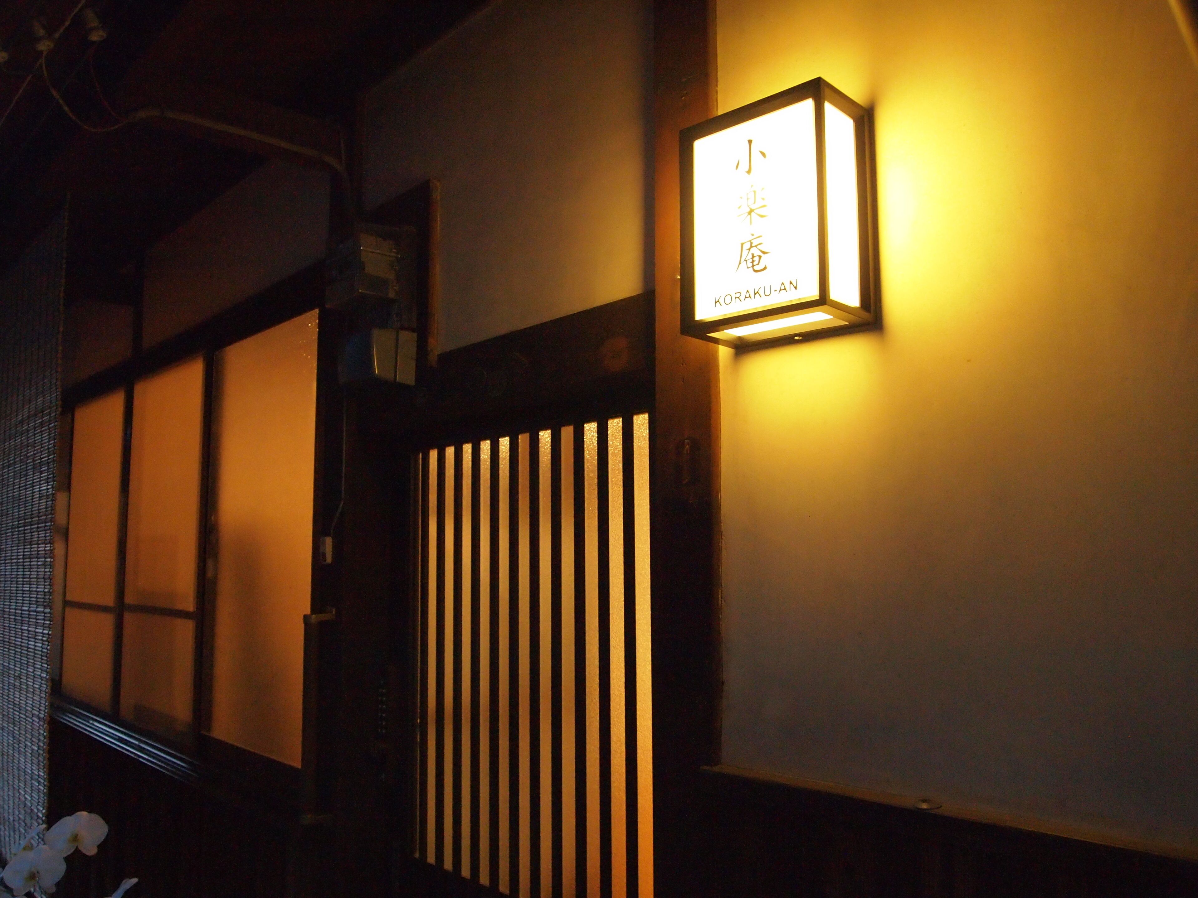 A traditional Japanese interior with sliding doors and a lit signboard.