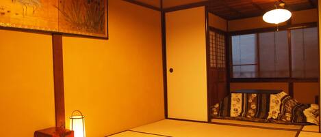 A traditional Japanese room with tatami flooring, a shoji screen, and a hanging lantern.