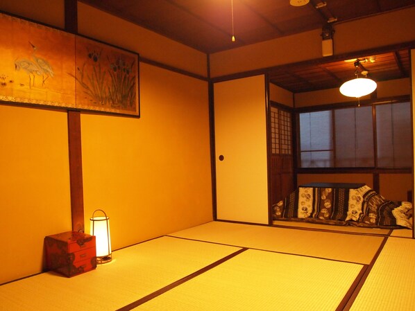 A traditional Japanese room with tatami flooring, a shoji screen, and a hanging lantern.