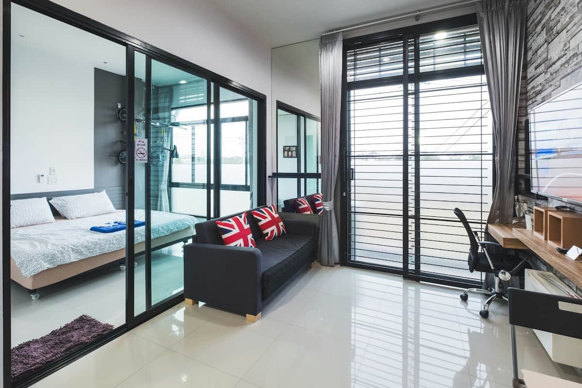 A modern living room with a sofa, a bed, and a desk.