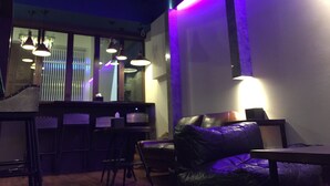 Un interior moderno con barra, asientos de cuero e iluminación colgante.
