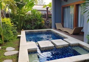 A rectangular swimming pool with a mosaic tile design, surrounded by a stone border and steps leading into the water. - Pipe Dream Villas Resort (Kuta)