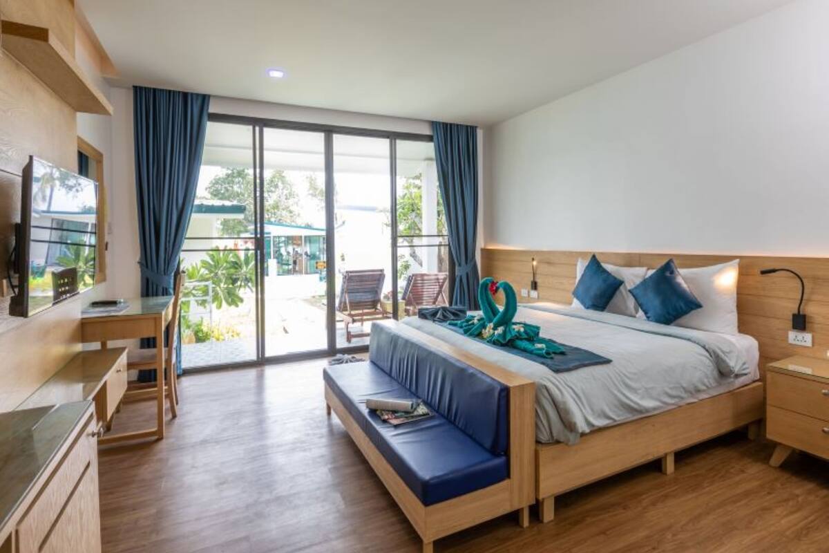 Une chambre d’hôtel moderne avec un lit en bois, un bureau et un banc.