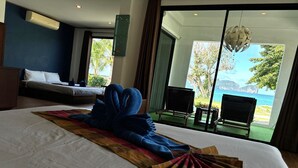 Een hotelkamer met een bed, een groot raam en uitzicht op zee.