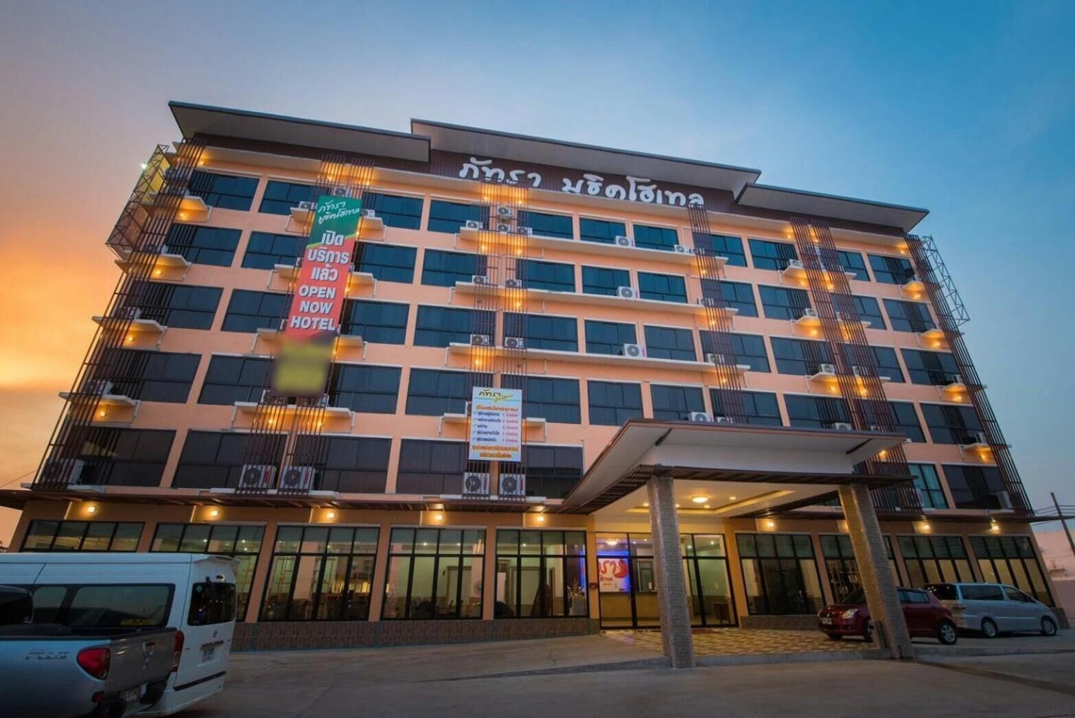 A multi-story hotel with a modern design, featuring balconies and a covered entrance.