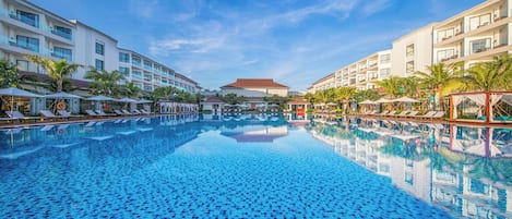 Una piscina al aire libre, sombrillas, sillones reclinables de piscina