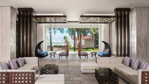 A modern living room with a sofa set, two armchairs, a coffee table, and a patterned rug. - Renaissance Danang Hoi An Resort & Spa (Da Nang)