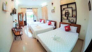 A hotel room with two beds, a desk with a chair, and a view of the outdoors through the window. - Rubis Hostel (Hue)
