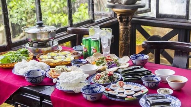 A table set with various dishes and drinks, likely for a meal. - Rubis Hostel (Hue)