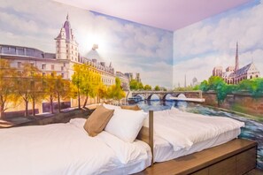 Un dormitorio con un mural de un paisaje urbano, una cama y una mesita de noche.