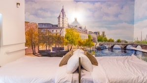 A bedroom with a mural of a cityscape, a bed with white linens, and a nightstand. - Kaohsiung Rouen (Kaohsiung)