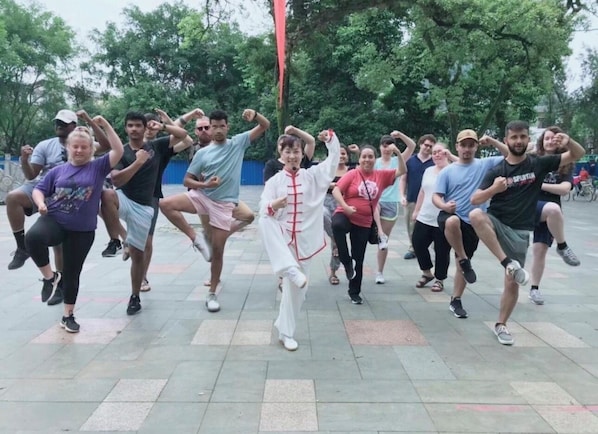 A group of people performing a martial arts routine outdoors.
