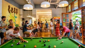 A pool table with balls, a bar area with bottles, and a wall with decorative elements. - Yangshuo Eden Inn (Guilin)
