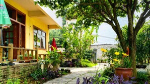 A yellow building with a wooden deck and potted plants. - Yangshuo Eden Inn (Guilin)