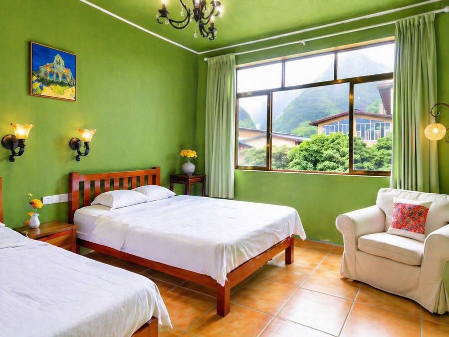 A hotel room with two beds, a chair, a painting, and a view of greenery outside.