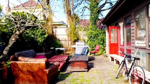 A patio with outdoor furniture, a bicycle, and a red building in the background. - St Kilda East backpackers' hostel (St. Kilda East)