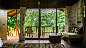A wooden cabin with a balcony overlooking lush greenery. - Kandy Cabana Eco Resort (Weligalla)