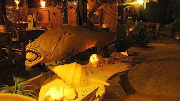 A restaurant with a large decorative fish centerpiece, tables, and chairs.