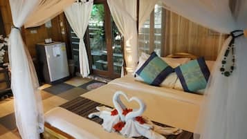 A bed with a canopy, a refrigerator, and a view of a garden.