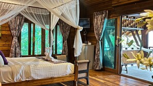 A wooden room with a bed, a chair, and a TV. - Viking Nature Resort (Ko Phi Phi)